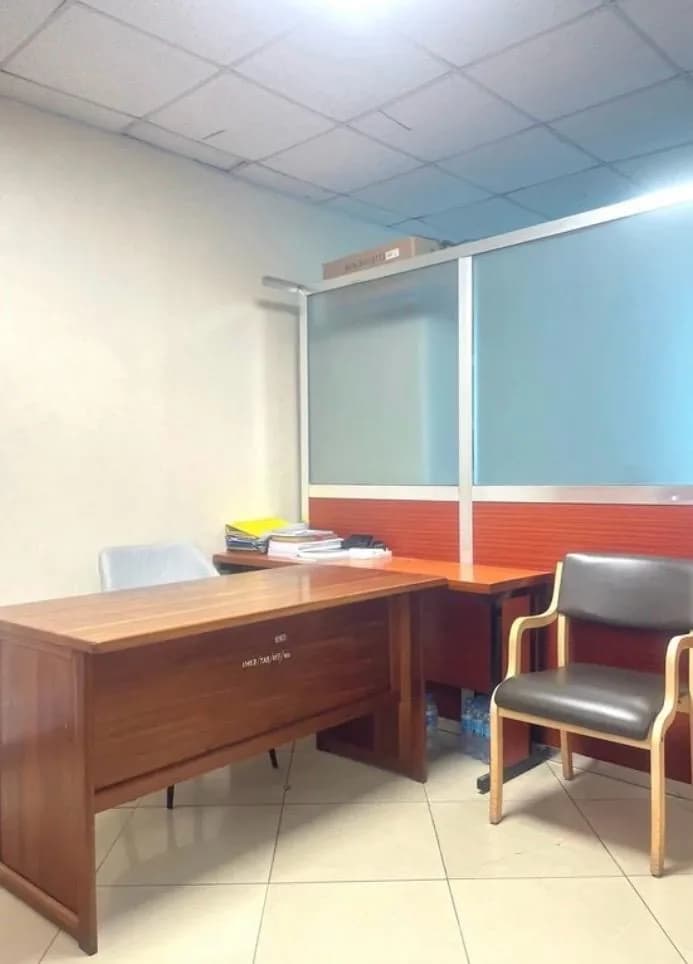 Dedicated wooden desk and guest chair at IMED HUB