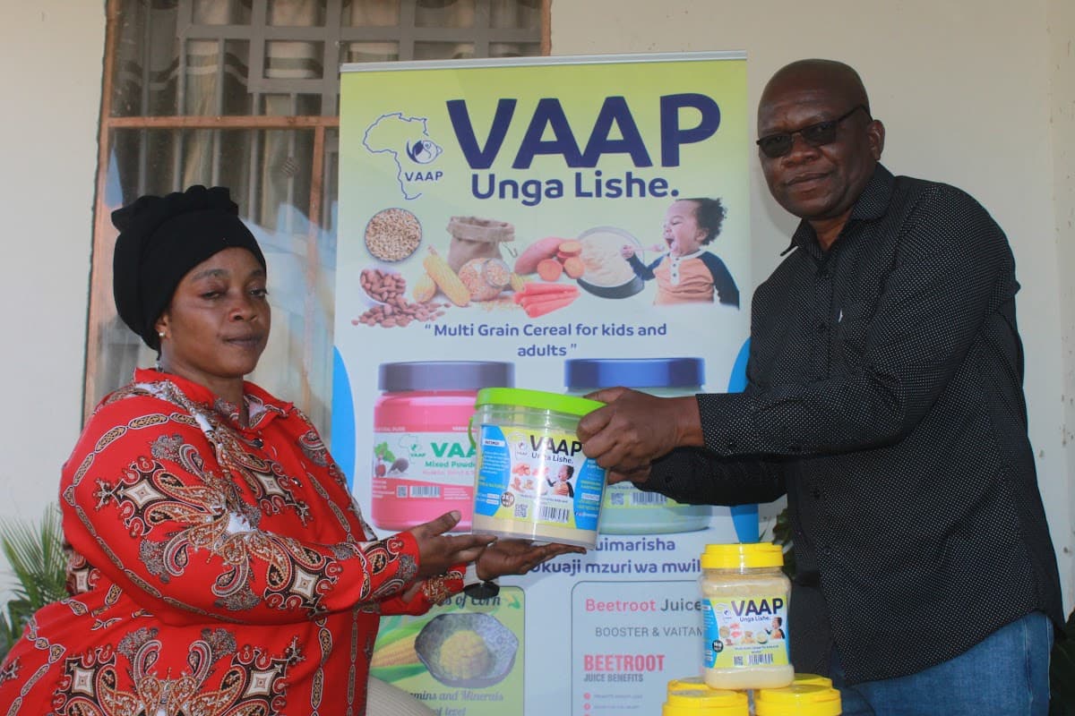 A Tanzanian nutrition entrepreneur presenting packaged VAAP Unga Lishe products during enterprise support